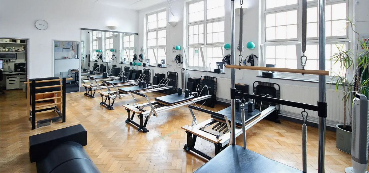 Row of Pilates Reformers and a ladder barrel in the London Colney studio